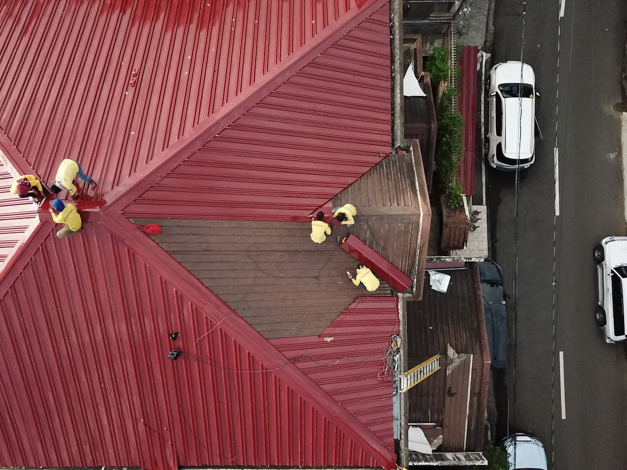 gallery-5 Aerial view of workers repairing a red metal roof in Quezon City, Philippines.